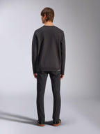 Alpinestars Positive Crew, felpa nera, vista posteriore su modello, indossata con jeans neri e sneakers casual, con polsini e orlo a coste, streetwear ispirato al motorsport