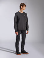 Alpinestars Positive Crew, felpa girocollo, nera, piccolo logo Alpinestars bianco sul petto, colletto a costine con cucitura a V, polsini e orlo a costine, indossata da un modello con pantaloni neri e sneakers, streetwear casual ispirato al motorsport
