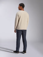 Alpinestars Positive Crew, felpa girocollo Off White, vista posteriore su modello, abbinata a jeans in denim scuro e sneakers nere, streetwear casual motorsport, con polsini e orlo a coste