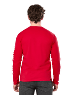 Vista posteriore di un uomo che indossa la t-shirt a maniche lunghe Alpinestars Committed CSF in rosso, abbinata a jeans grigio scuro, con logo Alpinestars bianco visibile sulla manica e un design posteriore minimalista.