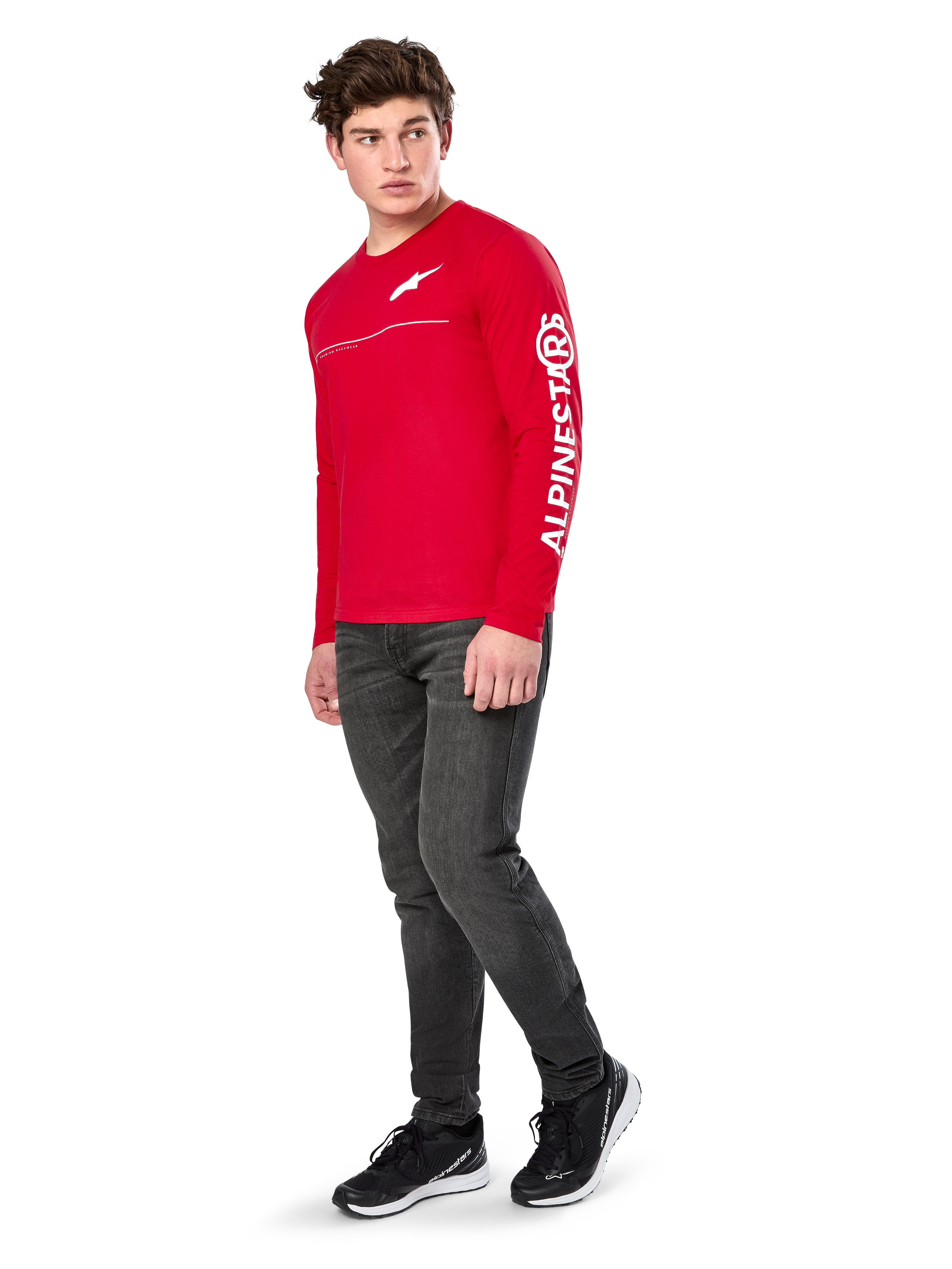 Alpinestars Committed CSF Tee, maglietta a maniche lunghe, rossa, con logo Astars bianco sul petto e marchio Alpinestars sulla manica, indossata da un modello con jeans scuri e sneakers nere, streetwear casual motorsport