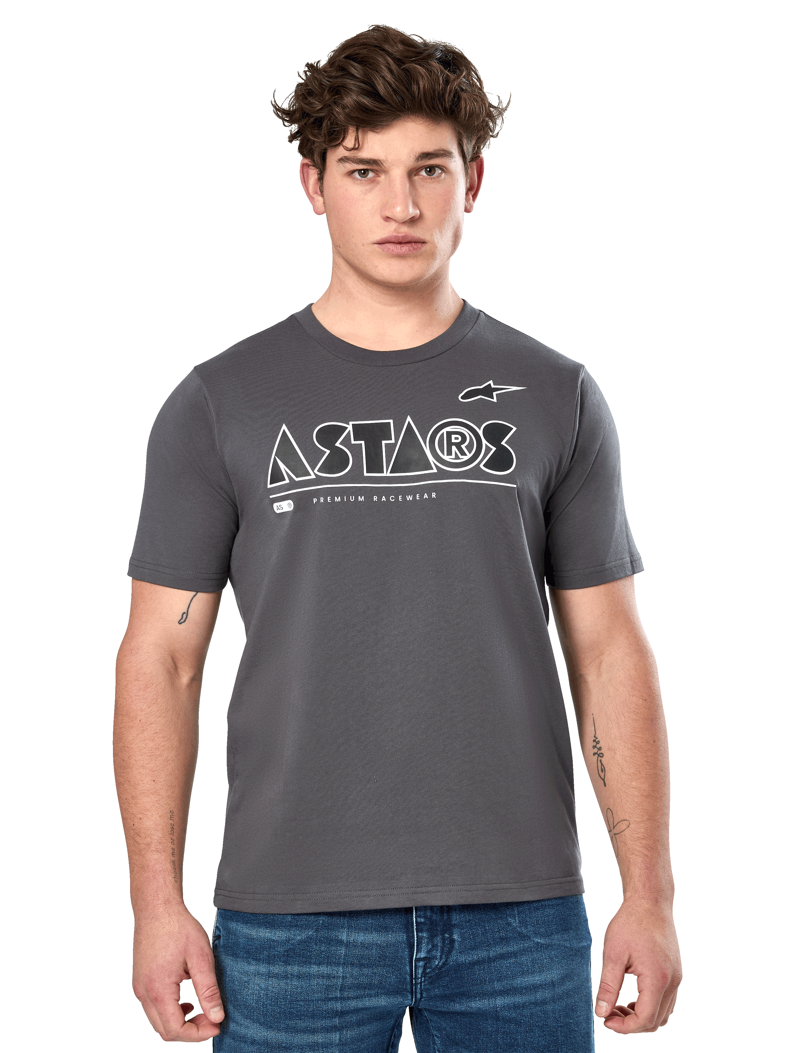 Alpinestars Cereal CSF Tee, t-shirt a maniche corte grigio antracite, indossata da un modello uomo con jeans blu, logo geometrico ASTARS bianco e scritta 'Premium Racewear', abbigliamento lifestyle casual ispirato al motorsport