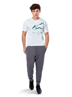 Alpinestars Geografica CSF Tee, maglietta a maniche corte, bianco, logo Astars verde con grafica multi-tech geografica, indossata con pantaloni sportivi grigi e sneakers nere, streetwear casual ispirato al motorsport