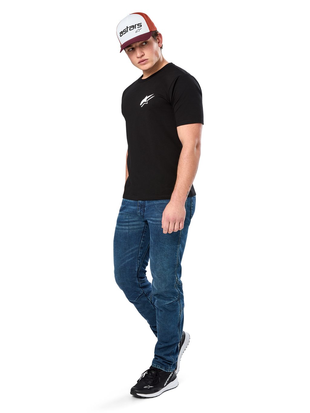 Alpinestars Formulate Csf Tee, maglietta a maniche corte, nero con logo Astars bianco sul petto, indossata da un modello con jeans blu, cappellino bordeaux e bianco e sneakers nere, streetwear casual ispirato al motorsport