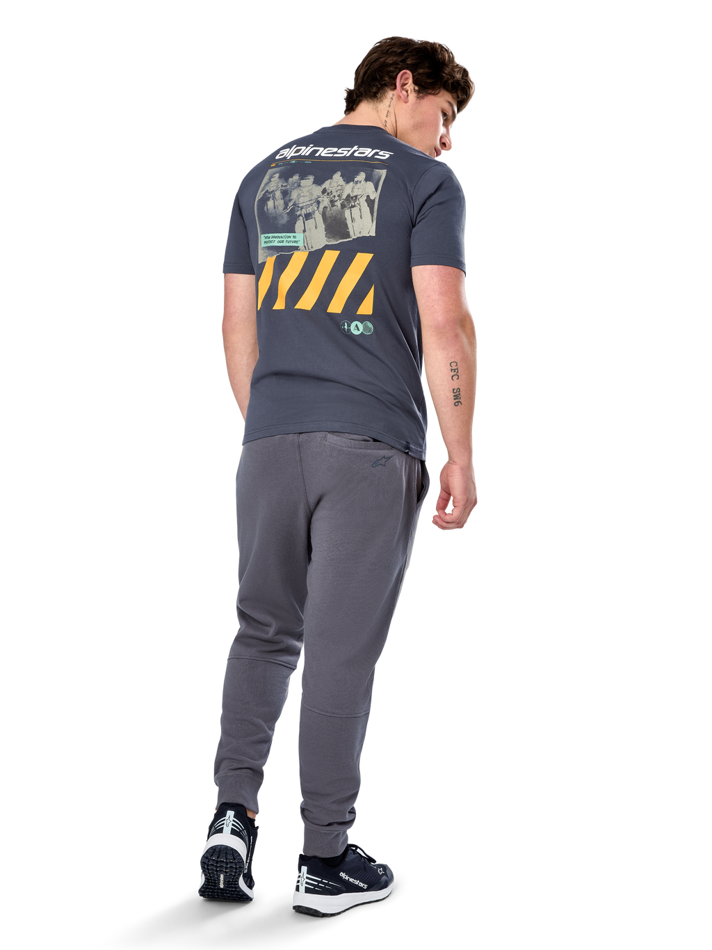 Alpinestars No Barrier CSF Tee, t-shirt a maniche corte, Charcoal, vista posteriore con grande grafica fotografica effetto invecchiato, strisce diagonali gialle e logo bianco, streetwear casual ispirato al motorsport