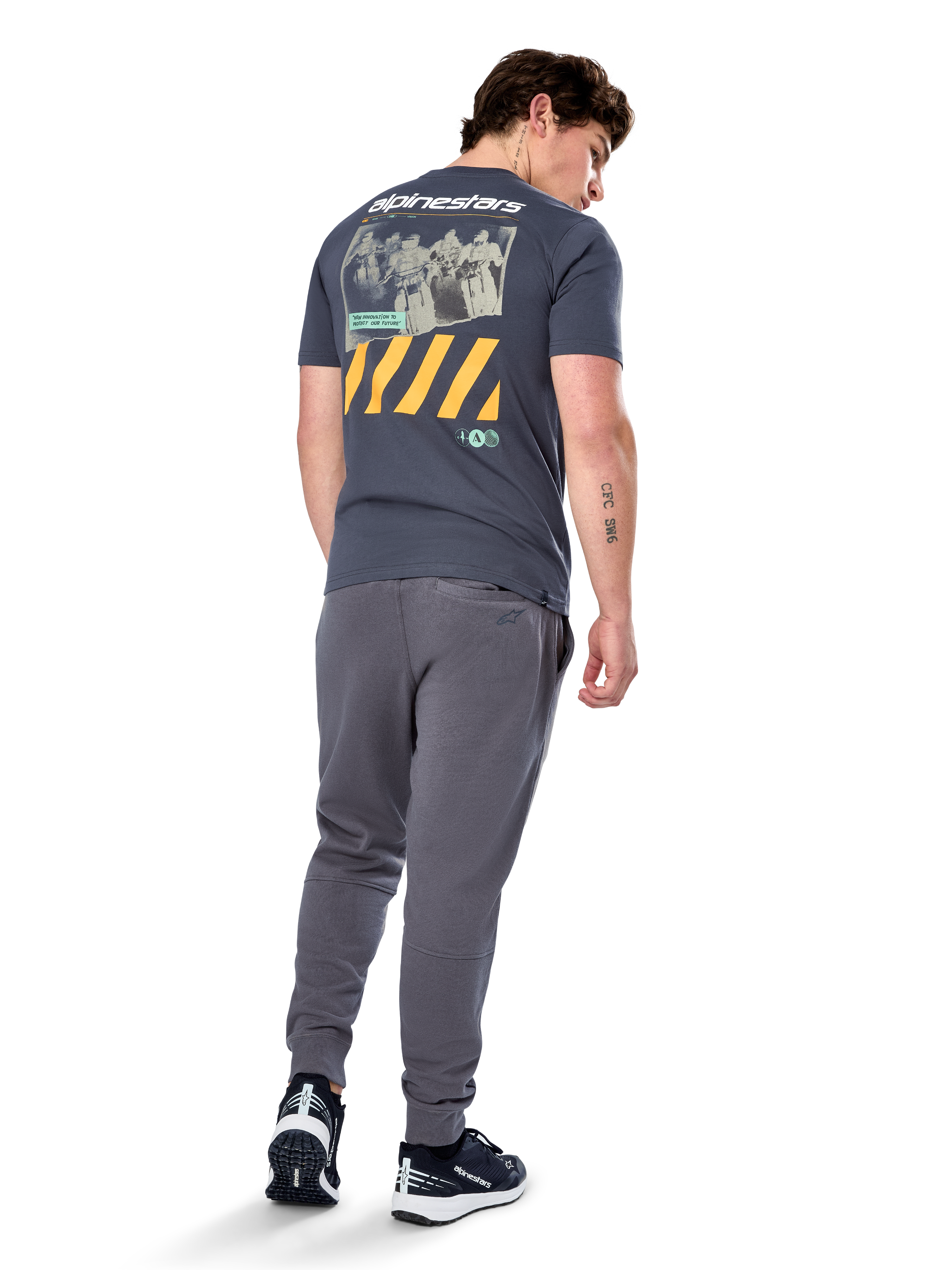 Alpinestars No Barrier CSF Tee, t-shirt a maniche corte, Charcoal, vista posteriore con grande grafica fotografica effetto invecchiato, strisce diagonali gialle e logo bianco, streetwear casual ispirato al motorsport