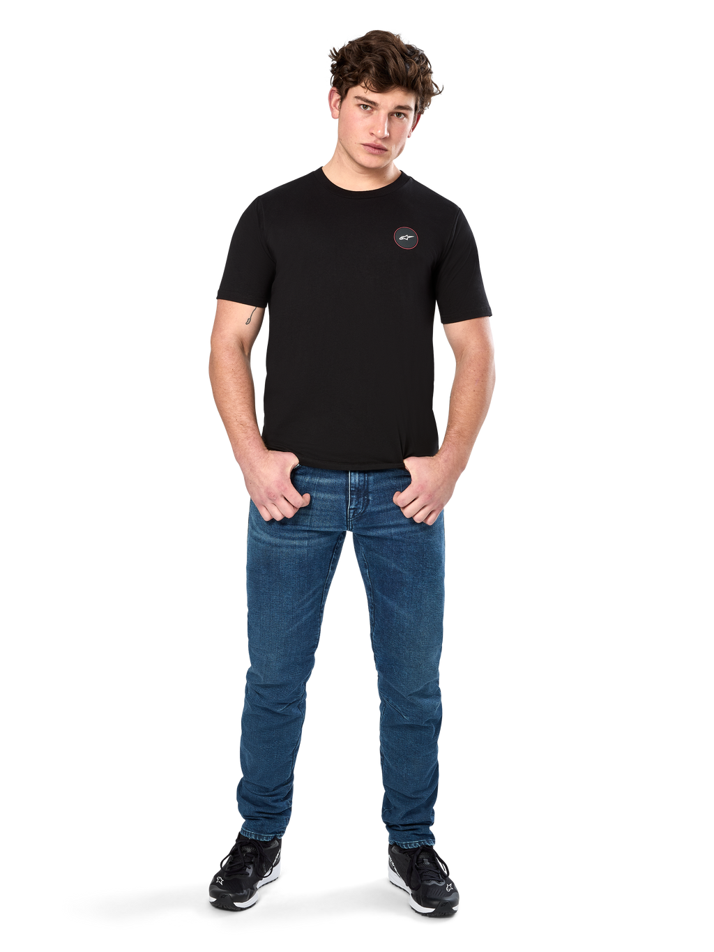 T-shirt Alpinestars Dot Carbon CSF, maglietta a maniche corte, nero, piccolo logo circolare Astars Dot sul petto, indossata con jeans blu e sneakers nere, streetwear casual ispirato al motorsport