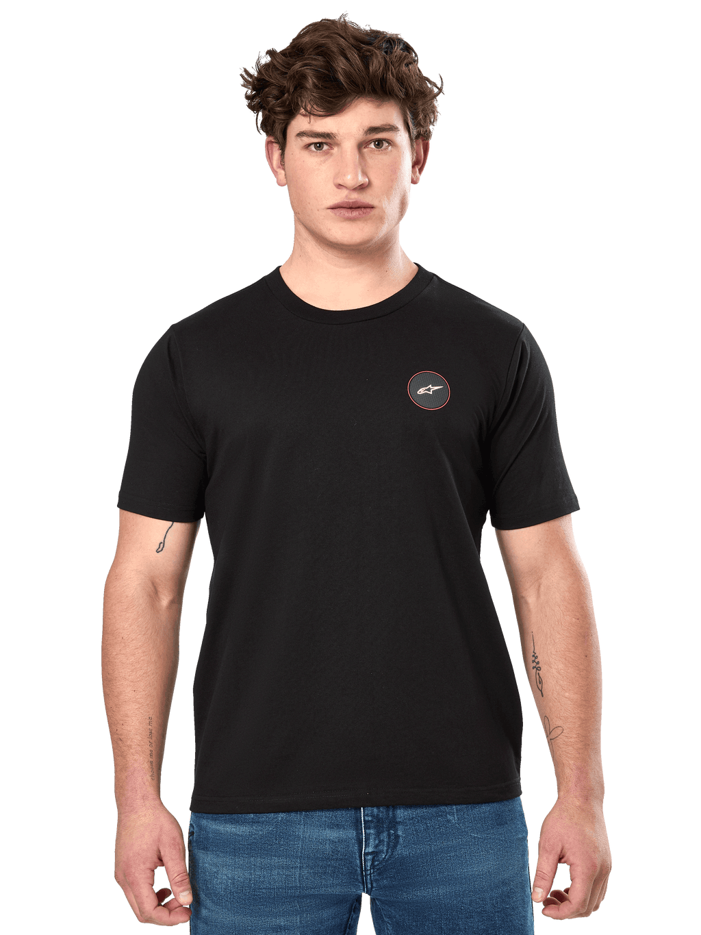 Alpinestars Dot Carbon CSF Tee, maglietta a maniche corte, nero, piccolo logo circolare sul petto con Astar bianca e bordo rosso, indossata da un modello con jeans blu, streetwear casual motorsport