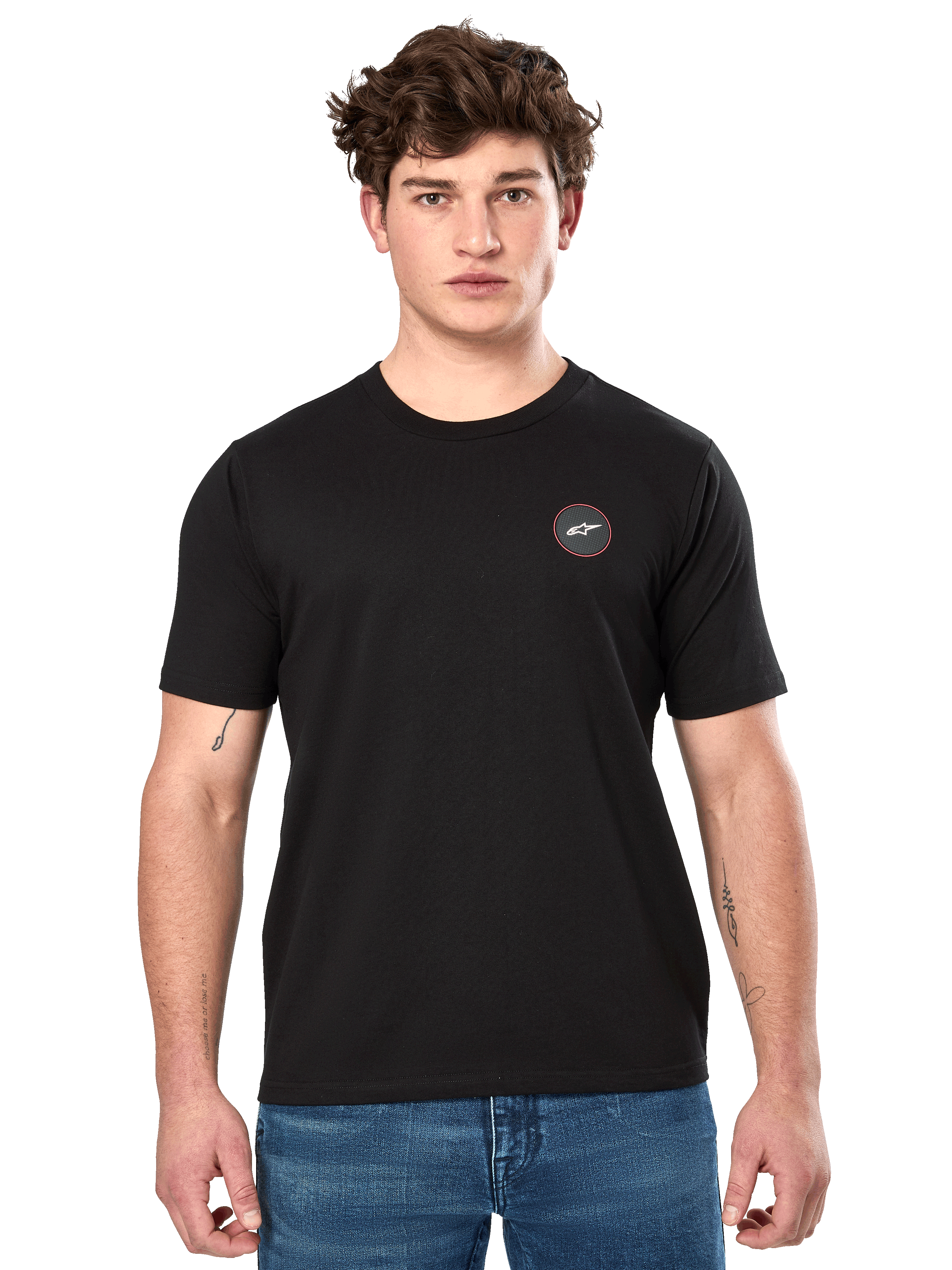 Alpinestars Dot Carbon CSF Tee, maglietta a maniche corte, nero, piccolo logo circolare sul petto con Astar bianca e bordo rosso, indossata da un modello con jeans blu, streetwear casual motorsport