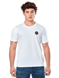 Alpinestars Dot Carbon CSF Tee, t-shirt bianca a maniche corte, modello maschile che indossa una t-shirt bianca con piccolo logo circolare nero sul petto e jeans blu, stile casual motorsport