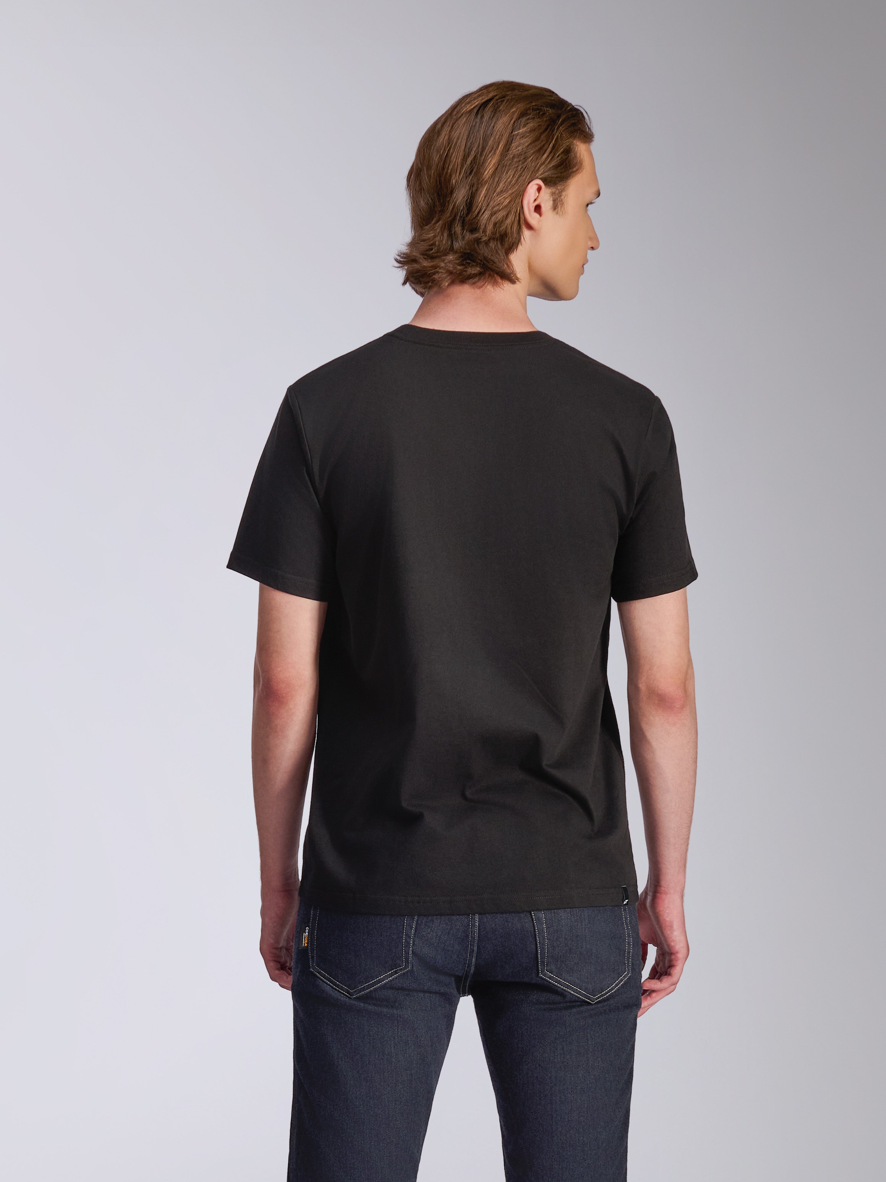 Alpinestars Luxo CSF Tee, maglietta a maniche corte, nero, vista posteriore, indossata da un modello con jeans blu scuro, streetwear casual ispirato al motorsport