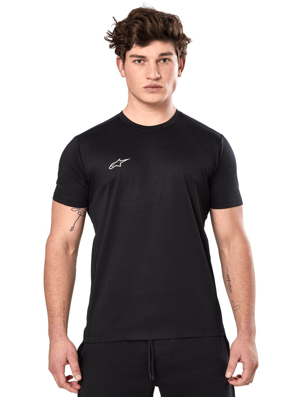 Alpinestars Point Performance Tee, maglietta tecnica a maniche corte, nera, piccolo logo Alpinestars bianco sul petto, indossata da un uomo con tatuaggi sulle braccia, abbigliamento sportivo tecnico casual