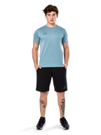 Alpinestars Point Performance Tee, t-shirt a maniche corte, blu ghiaccio, con un piccolo logo nero sul davanti, girocollo, indossata da un modello con pantaloncini neri e sneakers nere, abbigliamento sportivo casual traspirante