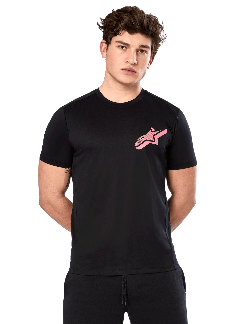 Alpinestars Attrition Performance Tee, t-shirt a maniche corte, nera con logo Astars rosa sul petto, indossata da un modello, abbigliamento tecnico casual da motorsport