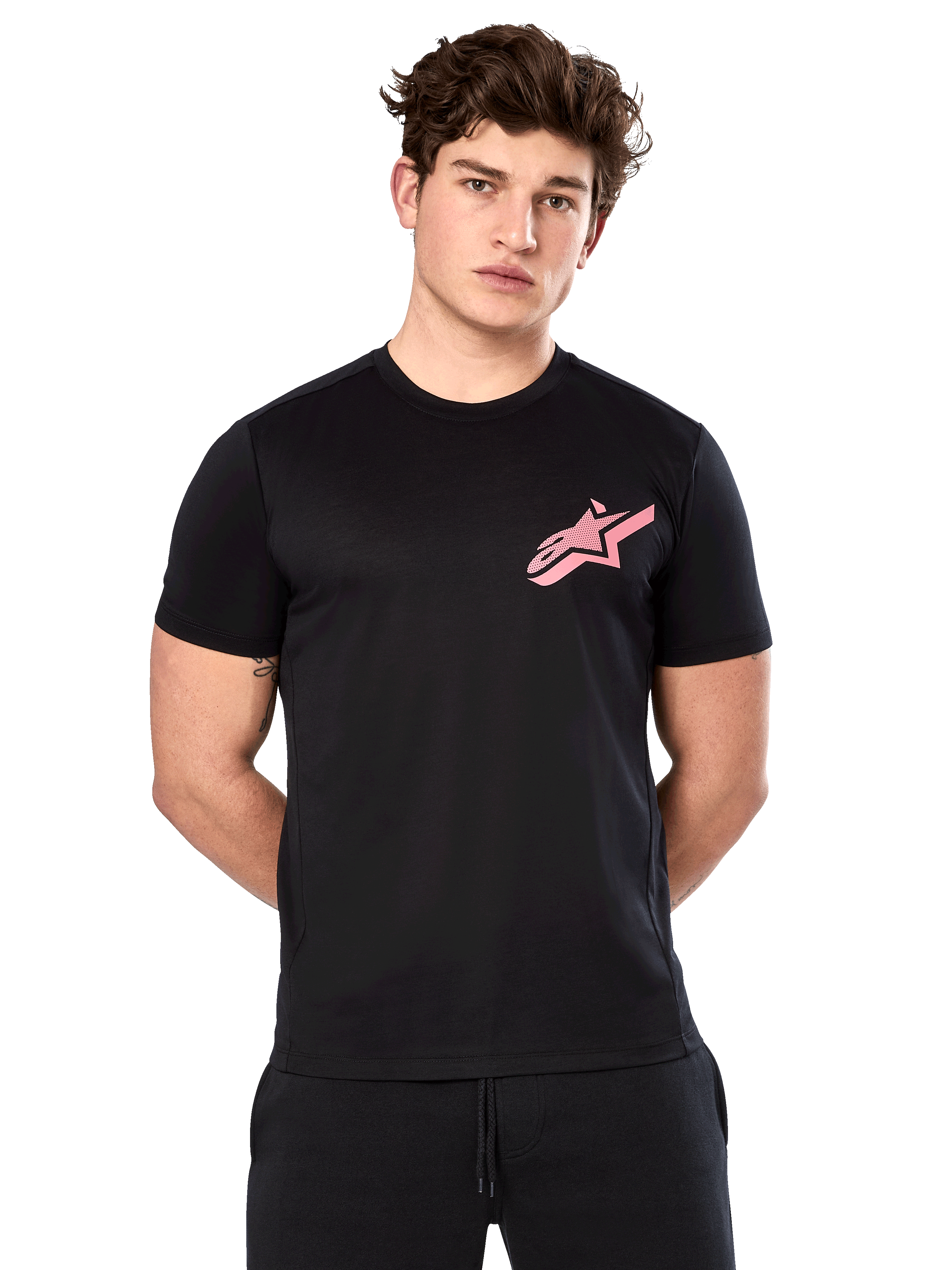 Alpinestars Attrition Performance Tee, t-shirt a maniche corte, nera con logo Astars rosa sul petto, indossata da un modello, abbigliamento tecnico casual da motorsport