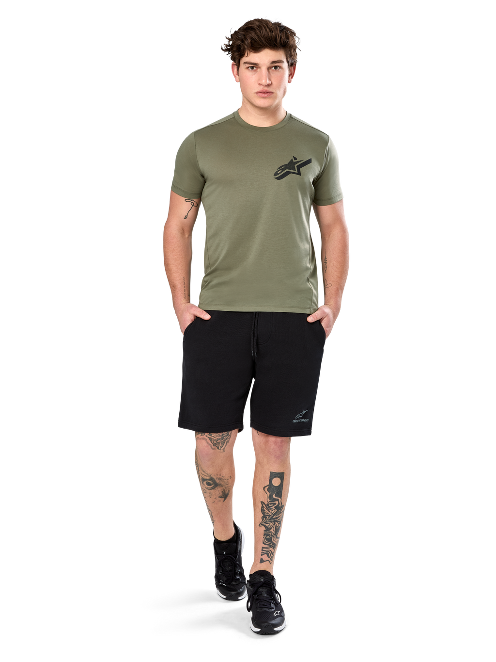 Alpinestars Attrition Performance Tee, t-shirt a maniche corte, verde chiaro, con logo Astars nero sul petto, indossata con pantaloncini sportivi neri e sneakers nere, scatto lifestyle casual performance sportswear