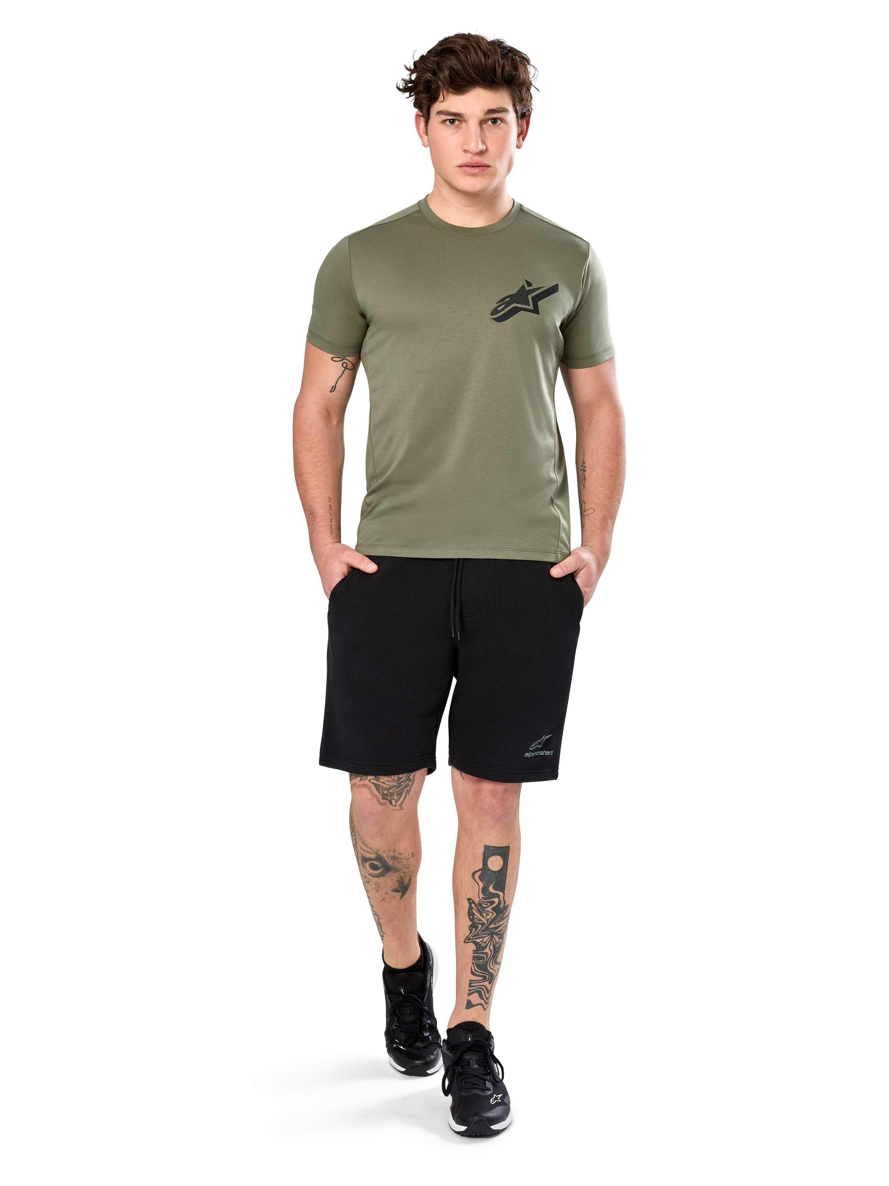 Alpinestars Attrition Performance Tee, t-shirt a maniche corte, verde chiaro, con logo Astars nero sul petto, indossata con pantaloncini sportivi neri e sneakers nere, scatto lifestyle casual performance sportswear