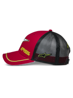 Alpinestars Exceed Trucker Hat, vista laterale rossa e nera, visiera curva con profilo giallo, pannelli posteriori in rete nera, ricamo giallo del logo AS e della stella, copricapo casual ispirato al motorsport