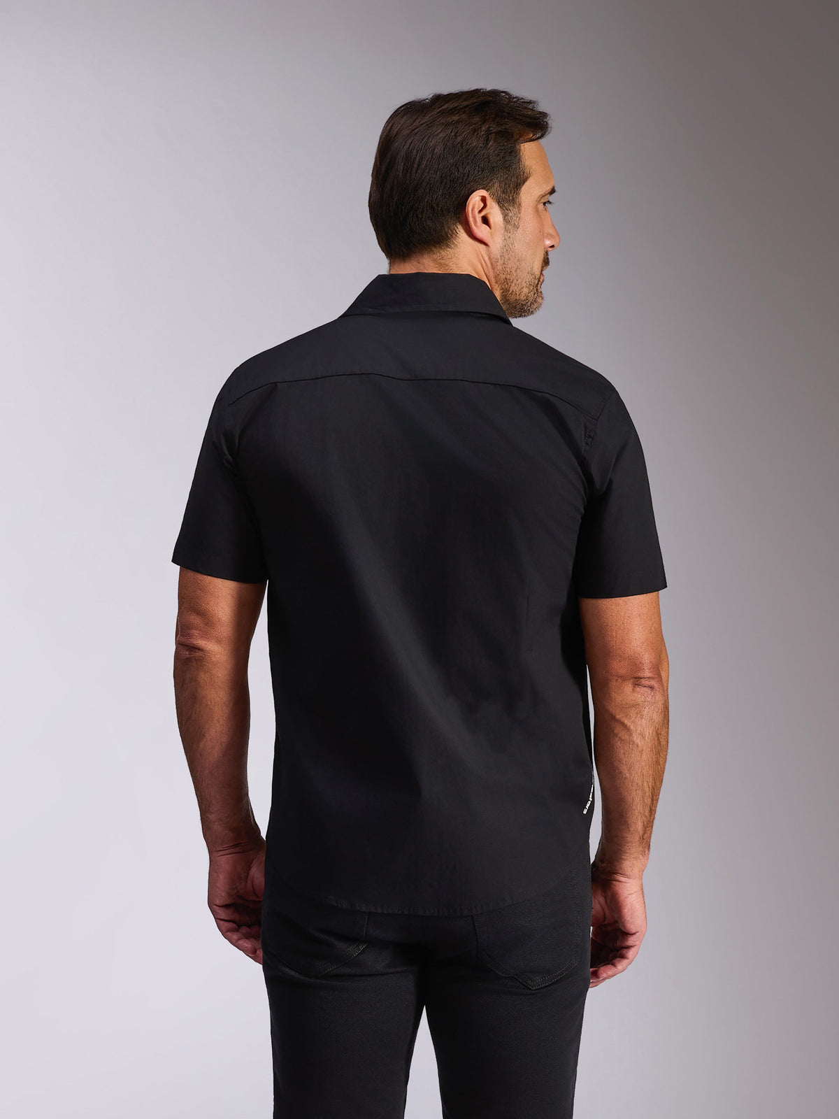 Alpinestars Strive Woven Shirt, camicia nera a maniche corte con bottoni, vista posteriore con carré e vestibilità sartoriale, streetwear casual ispirato al motorsport