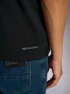 Alpinestars Polo Sport Impetus, vista del dettaglio del bordo inferiore e dello spacco laterale, nero con marchio Alpinestars grigio, abbigliamento sportivo casual ispirato al motorsport