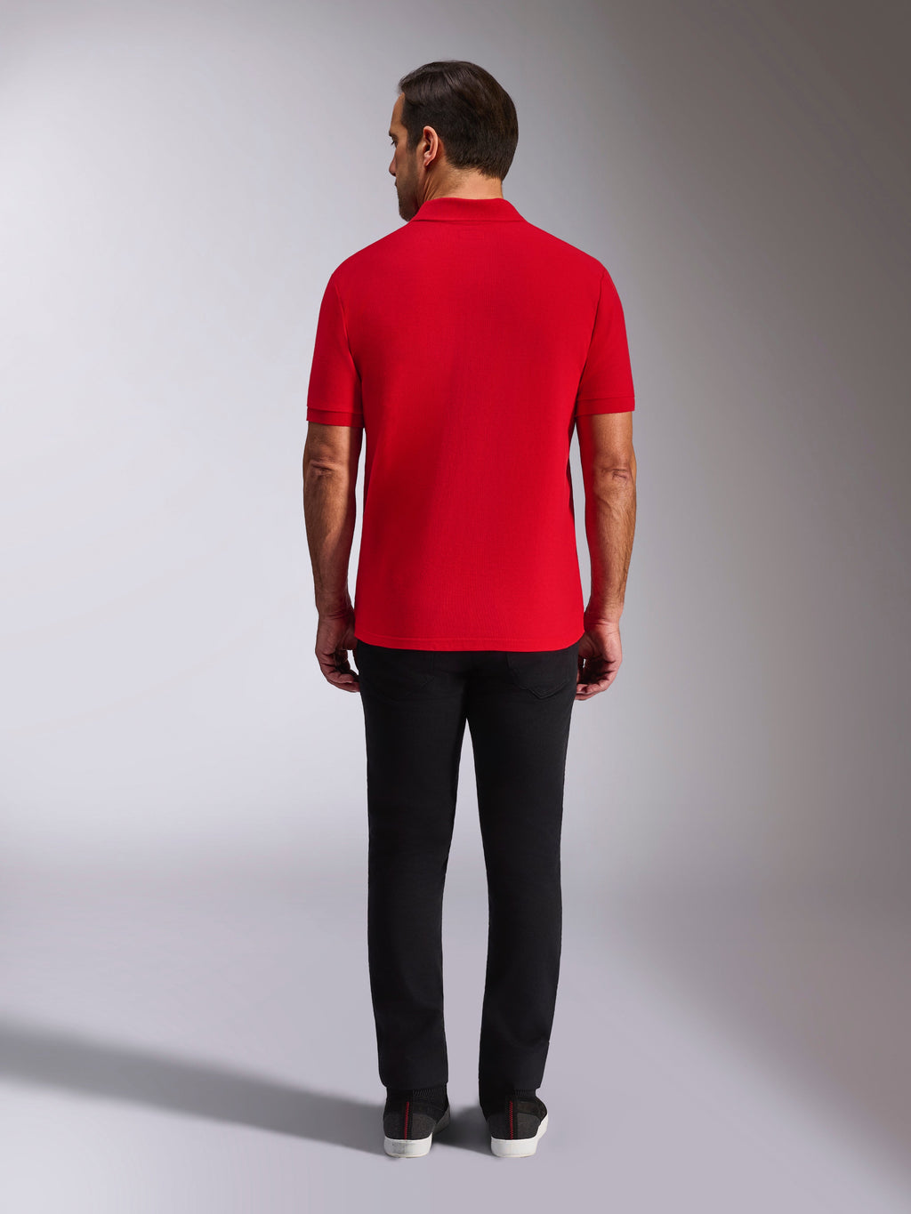 Polo Alpinestars Endeavor Classic, polo in piqué rossa, vista posteriore, indossata con pantaloni neri, streetwear casual per il motorsport con colletto e polsini a coste