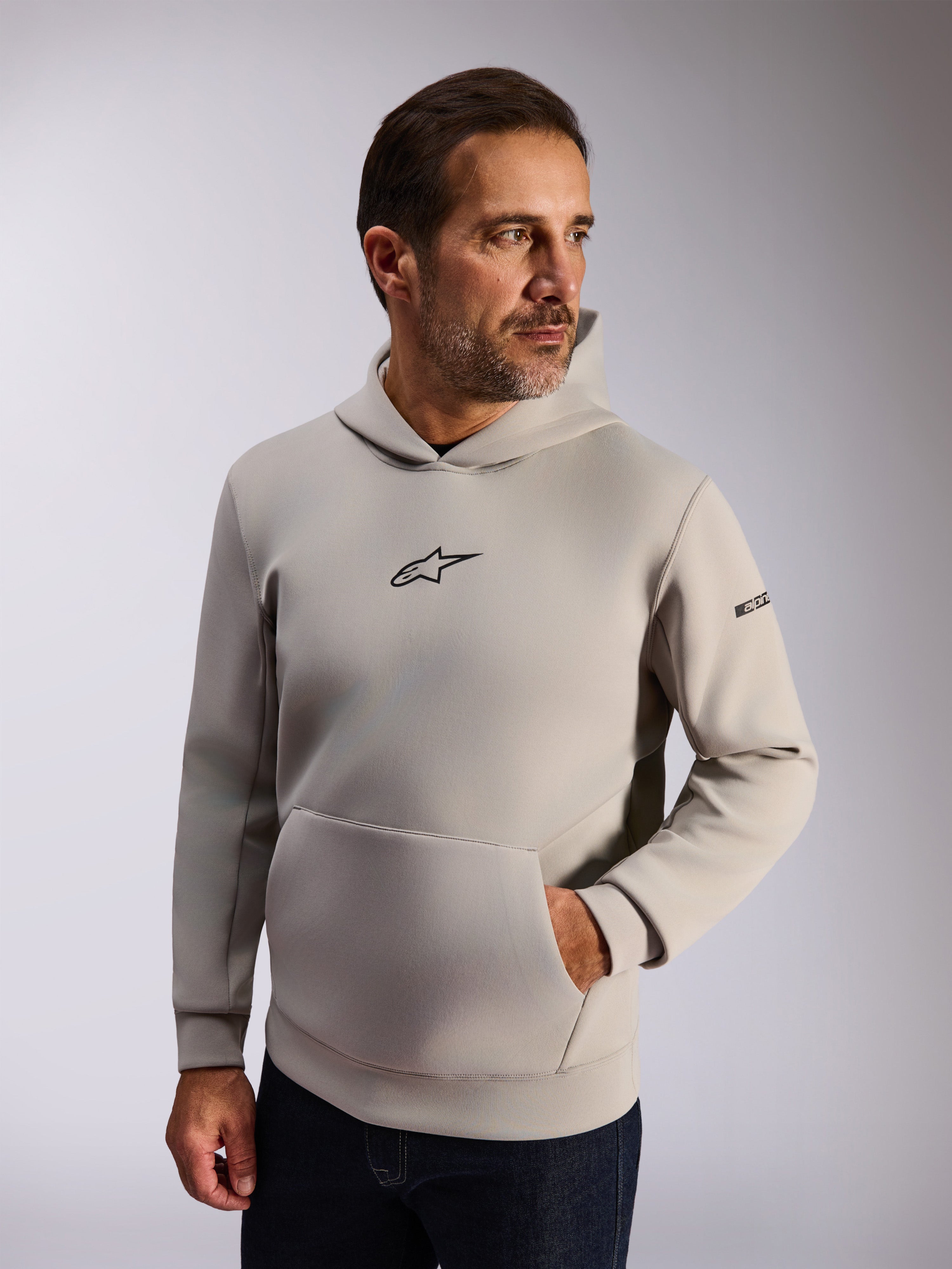 Alpinestars Insight Hoodie, streetwear casual lifestyle, pile grigio cemento, logo Astars nero frontale, tasca a marsupio, scritta sulla manica, cappuccio foderato in rete, abbigliamento moderno ispirato al motorsport