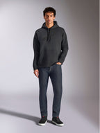 Alpinestars Emergent Oversized Hoodie, abbigliamento lifestyle streetwear casual, nero con logo ricamato in 3D tono su tono, cappuccio con cordino, tasca a marsupio, vestibilità oversize, indossata da un modello con jeans blu scuro e sneakers nere