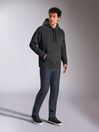 Alpinestars Emergent Oversized Hoodie, felpa casual streetwear nera, logo Astars ricamato in 3D tono su tono sul petto, tasca a marsupio, vestibilità oversize, indossata da un modello con jeans in denim blu scuro e sneakers nere