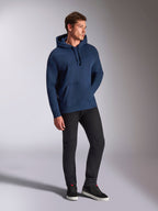 Felpa con cappuccio Alpinestars Emergent Oversized, blu navy, indossata da un modello con pantaloni neri e sneakers, con logo Astars ricamato in 3D, tasca a marsupio e cappuccio con cordino, streetwear casual ispirato al motorsport.