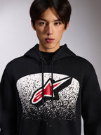 Alpinestars Obsessed Hoodie, felpa nera con cappuccio, con logo Astars rosso e bianco all'interno di una grafica bianca a gradazione puntinata MX sul petto, indossata da un modello, abbigliamento streetwear casual da motorsport con cappuccio regolabile con cordino