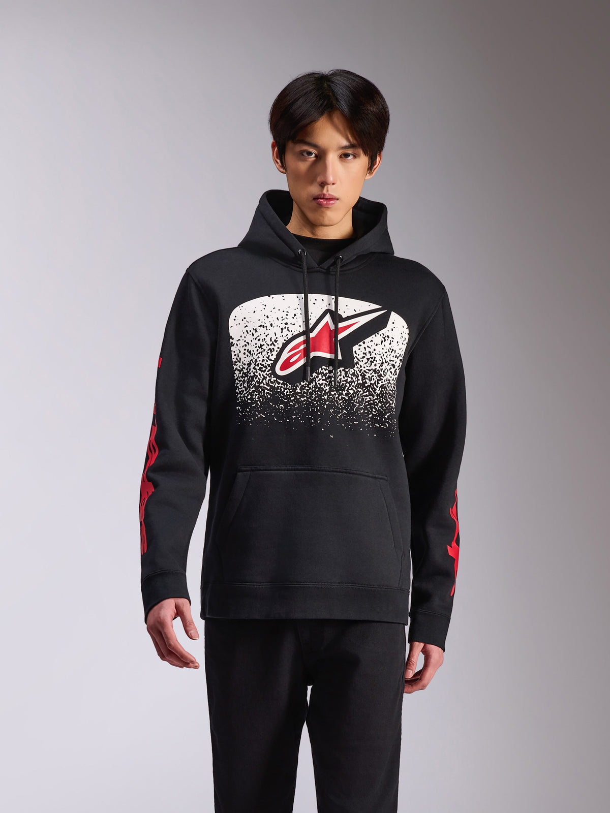 Alpinestars Obsessed Hoodie, abbigliamento sportivo casual, pullover nero con grande logo Astars frontale, sfumatura MX punteggiata in bianco e nero, branding rosso sulle maniche, cappuccio con cordino e polsini a coste