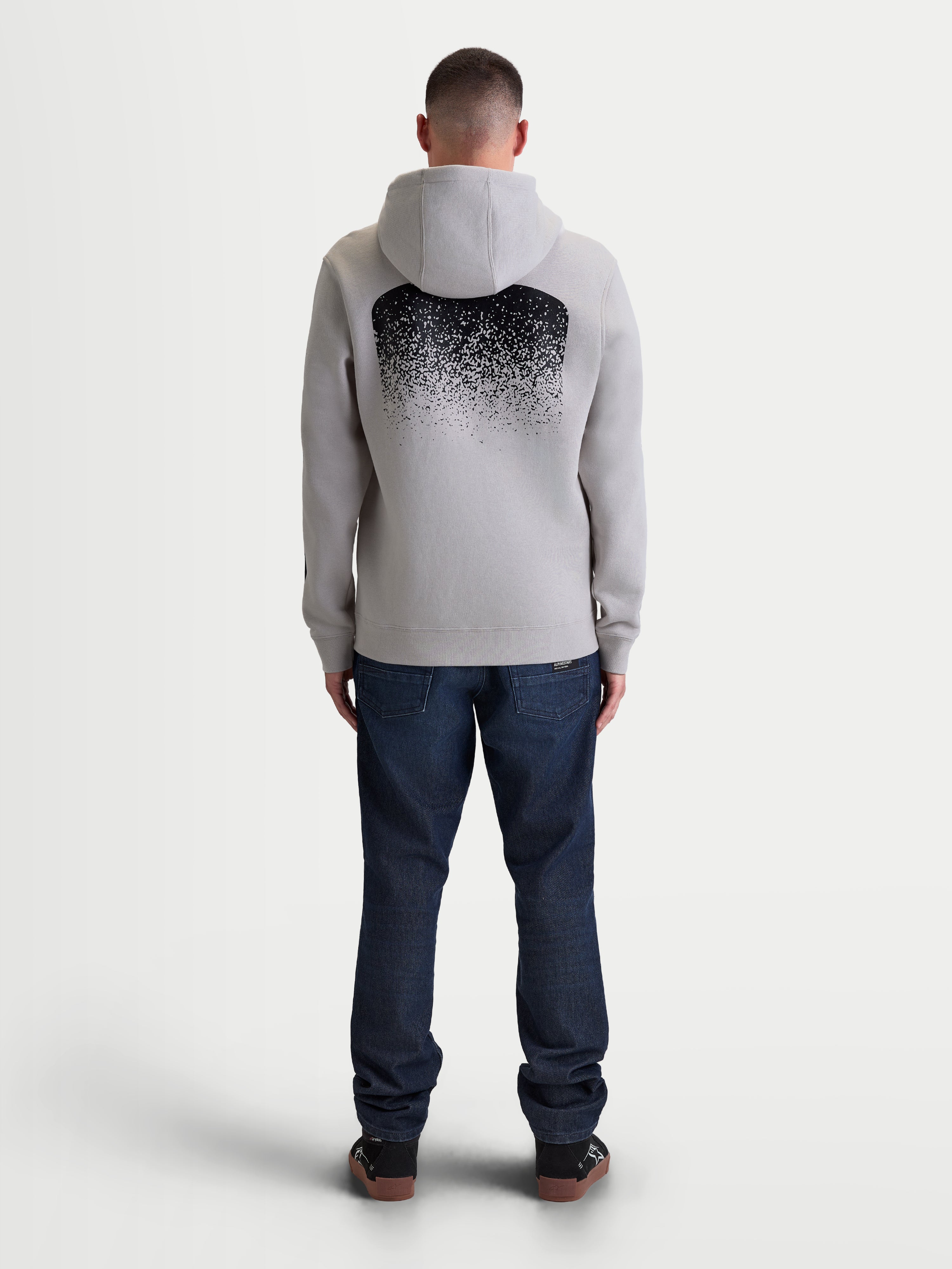 Alpinestars Felpa con cappuccio Obsessed, felpa sportswear da uomo in pile grigio cemento e nero, vista posteriore con grande grafica sfumata ispirata all'MX, abbigliamento casual motorsport lifestyle con cappuccio e bordi a coste