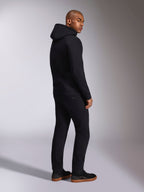 Alpinestars Felpa con cappuccio Ellipsoid, streetwear casual nero, vista posteriore su modello, felpa pullover con cappuccio, polsini e orlo a coste, indossata con pantaloni neri e sneakers, design moderno ispirato al motorsport