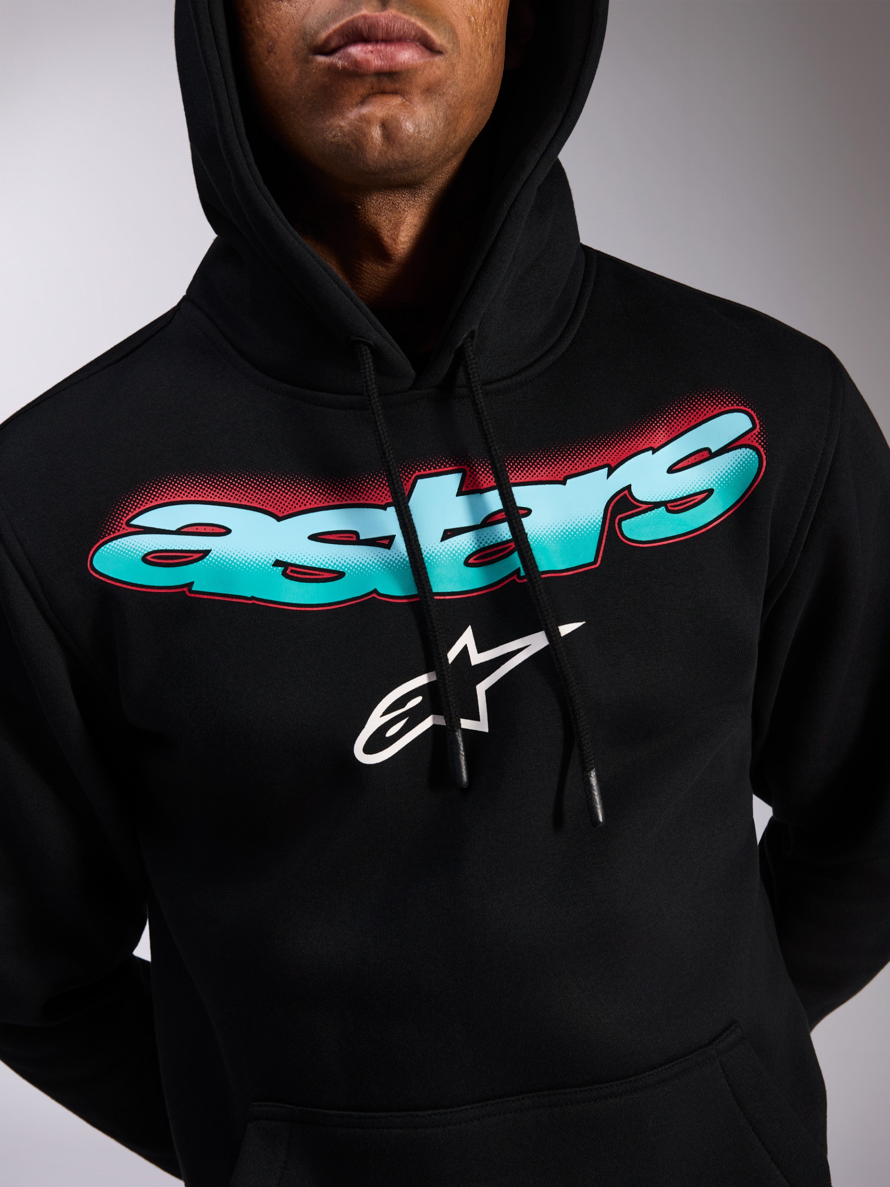 Alpinestars Ellipsoid Hoodie, felpa pullover nera, scritta Astars con gradiente di colore verde acqua e blu e accenti halftone rossi, logo a stella bianco, cappuccio con cordino, streetwear casual ispirato al motorsport