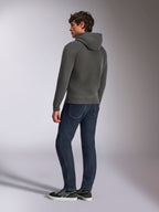 Felpa con cappuccio Alpinestars Ellipsoid, abbigliamento sportivo casual, grigio canna di fucile, vista posteriore su modello maschile, cappuccio con cordino, maniche lunghe, polsini e bordo a coste, abbinata a jeans scuri e sneakers
