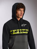 Felpa con cappuccio Alpinestars Parallel, streetwear casual a blocchi di colore, parte superiore nera e parte inferiore grigio gunmetal, fascia gialla neon sul petto con logo Alpinestars nero, logo Astars bianco, felpa pullover con cappuccio e coulisse