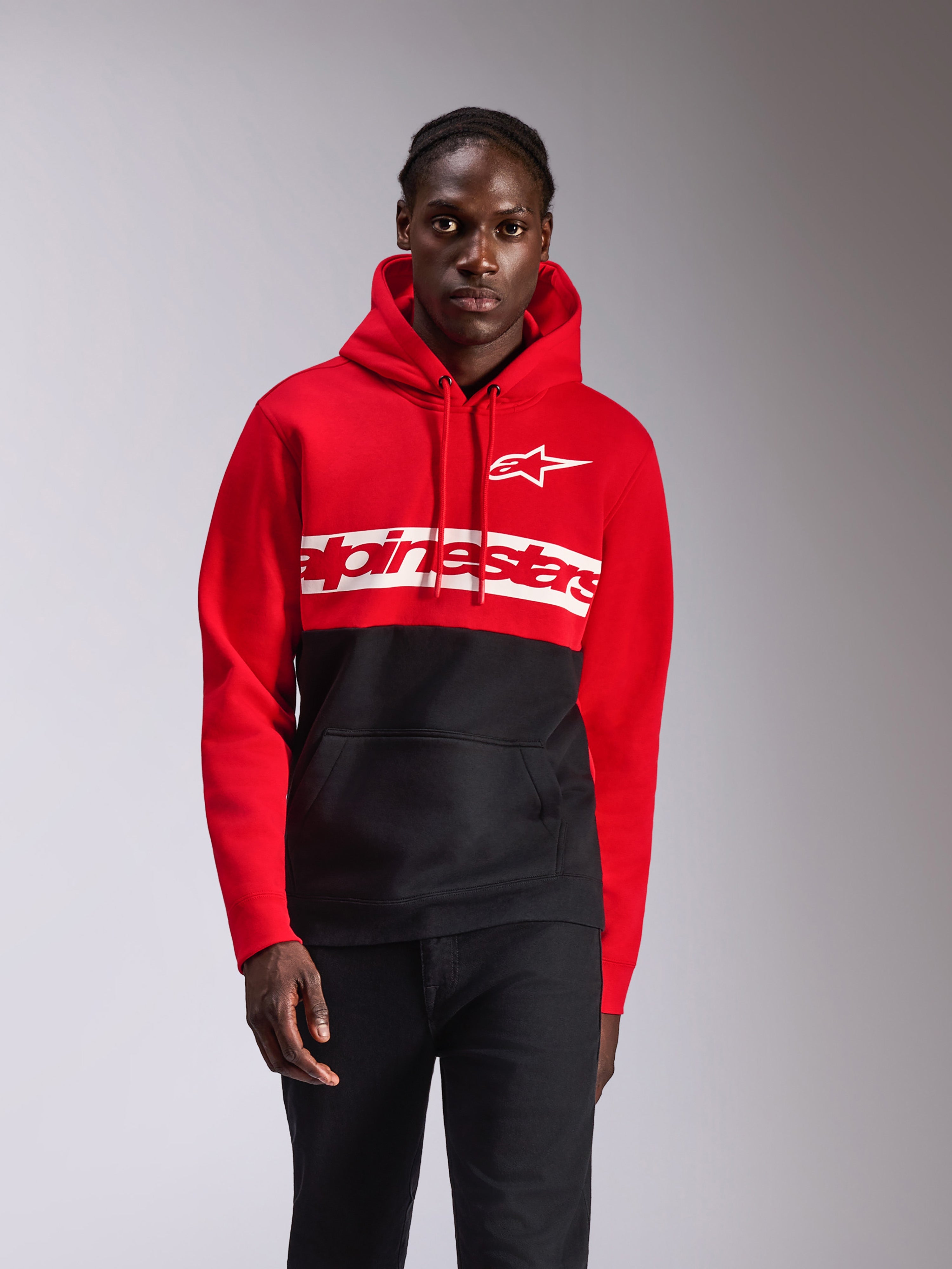 Alpinestars Parallel Hoodie, streetwear casual, a blocchi di colore rosso e nero, grande logo Alpinestars e logo Astars bianchi sul petto, cappuccio con cordino, tasca a marsupio frontale, design ispirato al motorsport