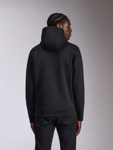 Alpinestars Pulse Hoodie, nera, vista posteriore su modello, streetwear casual, felpa in pile con cappuccio dal design nero a tinta unita, polsini e orlo a coste, abbinata a pantaloni neri.