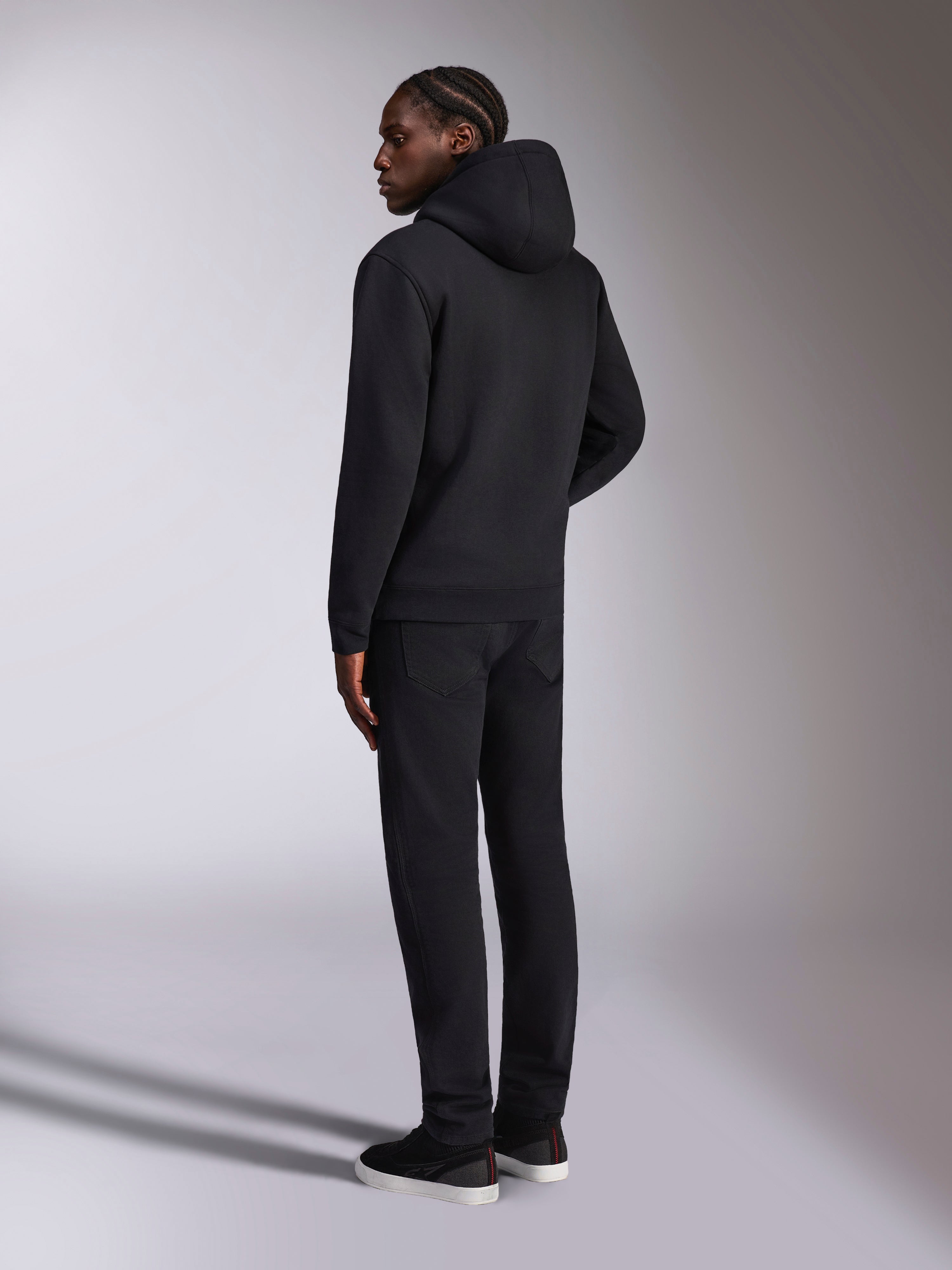 Alpinestars Pulse Hoodie, streetwear casual, nero, vista posteriore del modello che indossa una felpa con cappuccio in tinta unita nera, design minimalista con polsini e orlo a coste