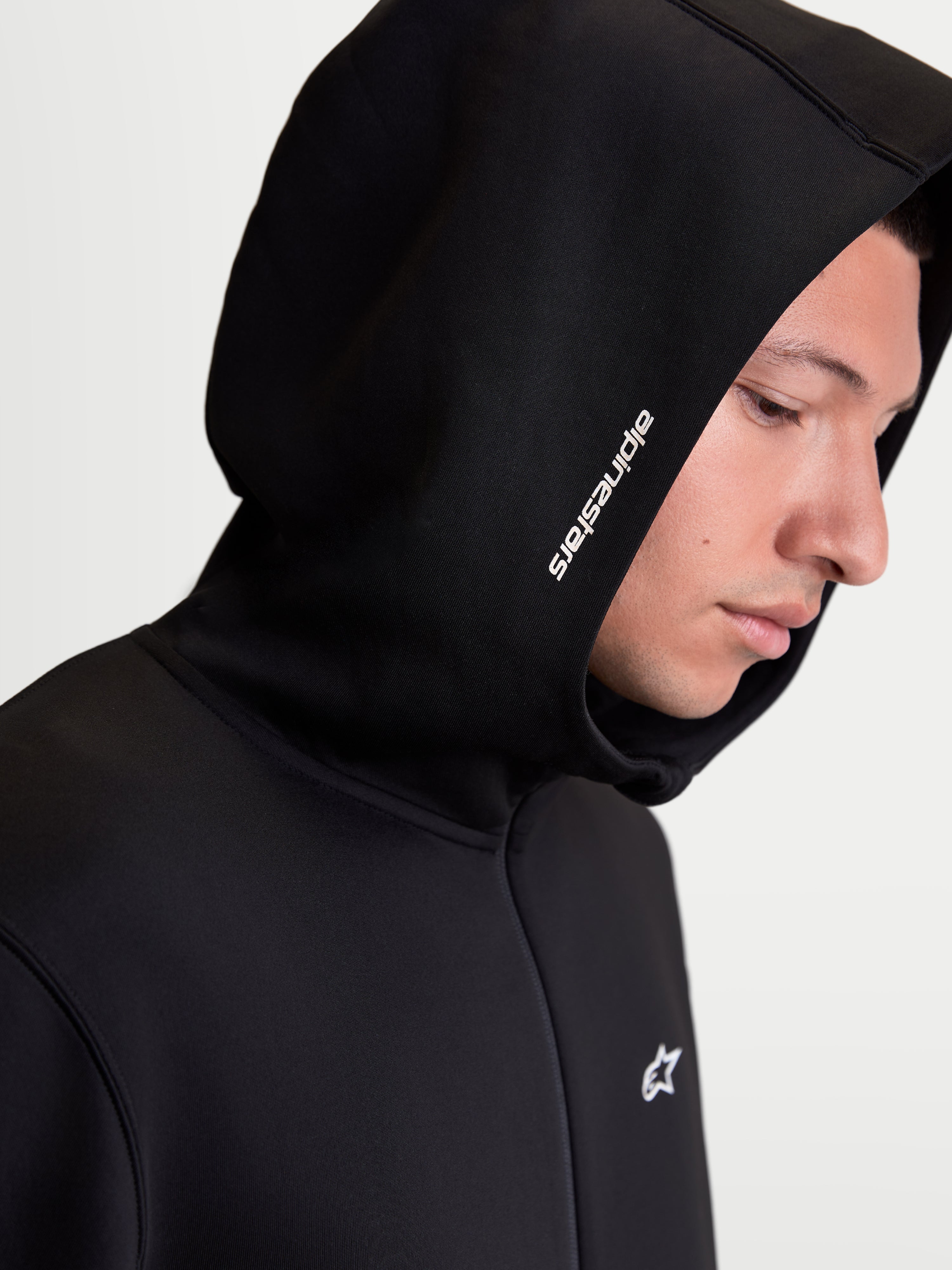 Alpinestars Felpa con cappuccio Cypher, felpa sportswear da uomo con zip, nera, vista in primo piano del cappuccio a collo alto con logo Alpinestars bianco e tessuto in pile tecnico