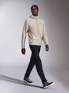 Felpa con cappuccio Alpinestars Cypher, pile con zip integrale grigio cemento, cappuccio a collo alto, piccolo logo Astars sul petto, indossata da un modello che cammina, abbinata a pantaloni neri e sneakers nere e grigie, abbigliamento sportivo casual ispirato al motorsport.