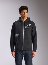 Alpinestars Transverse Hoodie, felpa nera con cappuccio e zip frontale, logo Astars bianco e grafica One Goal sul davanti, indossata da un modello con jeans scuri, abbigliamento streetwear casual ispirato al motorsport