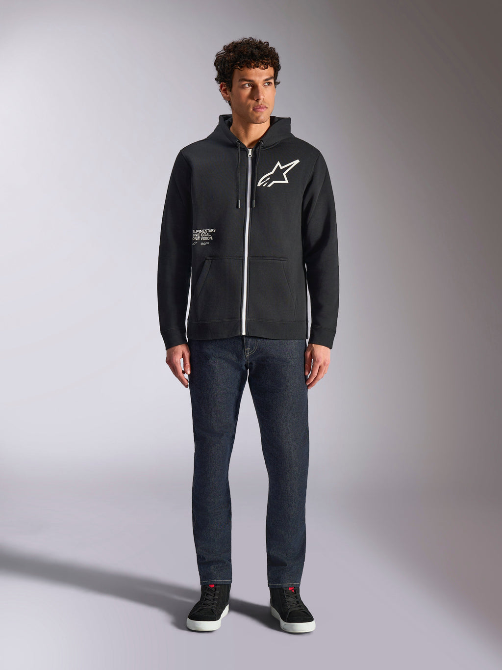 Alpinestars Felpa con cappuccio Transverse, felpa casual con zip frontale, nera, logo Astars bianco sul petto e stampa 'One Goal' sul davanti, cappuccio con coulisse, abbinata a jeans scuri e sneakers nere, streetwear lifestyle motorsport