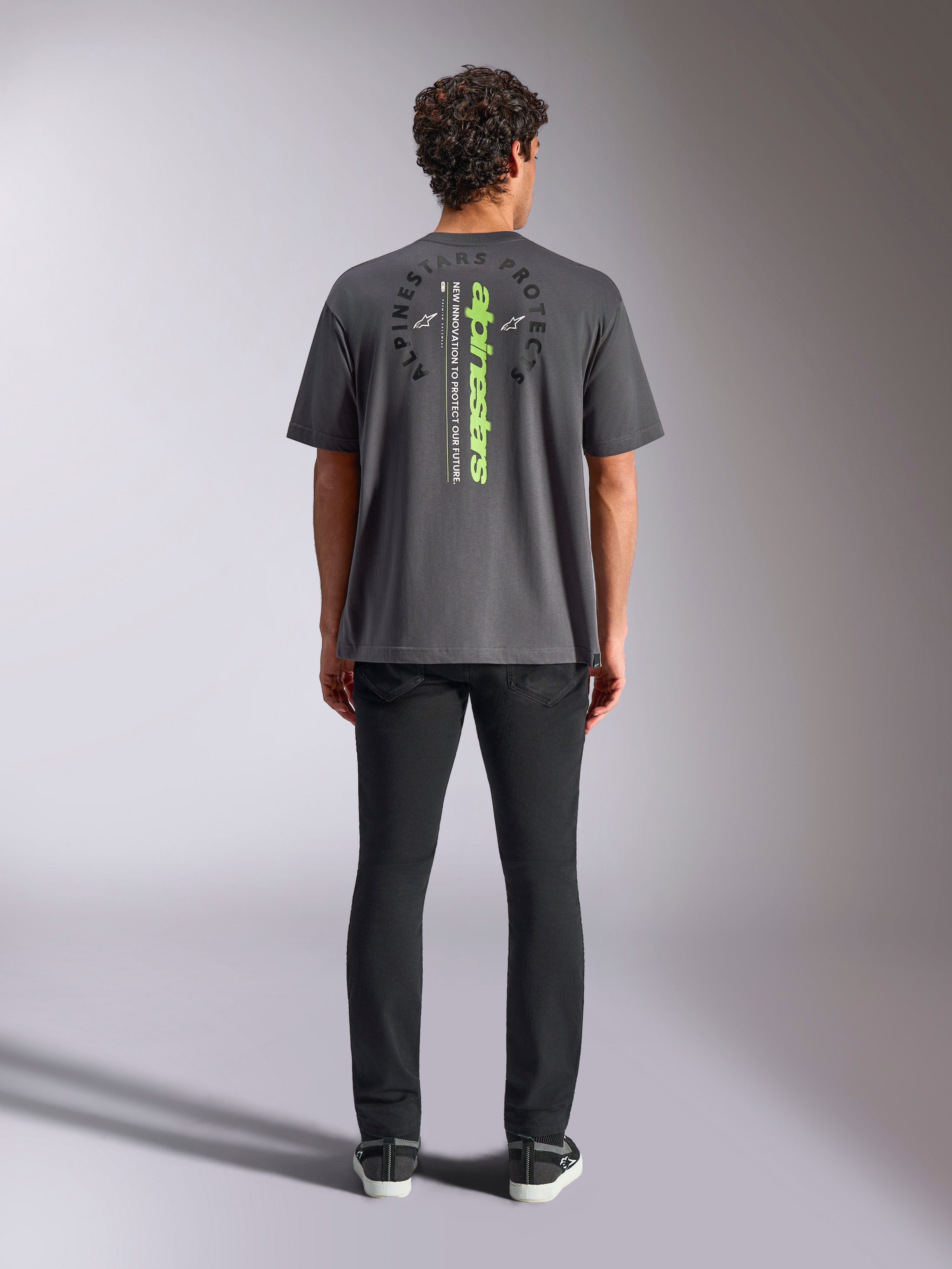 Alpinestars Overhang Oversized CSF Tee, t-shirt a maniche corte, grigio antracite, vista posteriore con logo Alpinestars verticale verde neon e testo grafico, vestibilità oversize, streetwear casual motorsport