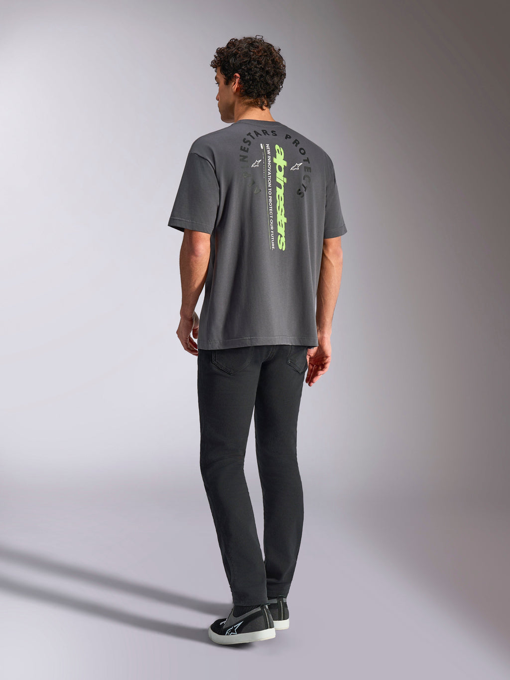 Maglietta Alpinestars Overhang Oversized CSF, t-shirt a maniche corte, grigio antracite, con marchio verticale verde lime e grafica circolare Alpinestars Protects sul retro, streetwear casual motorsport