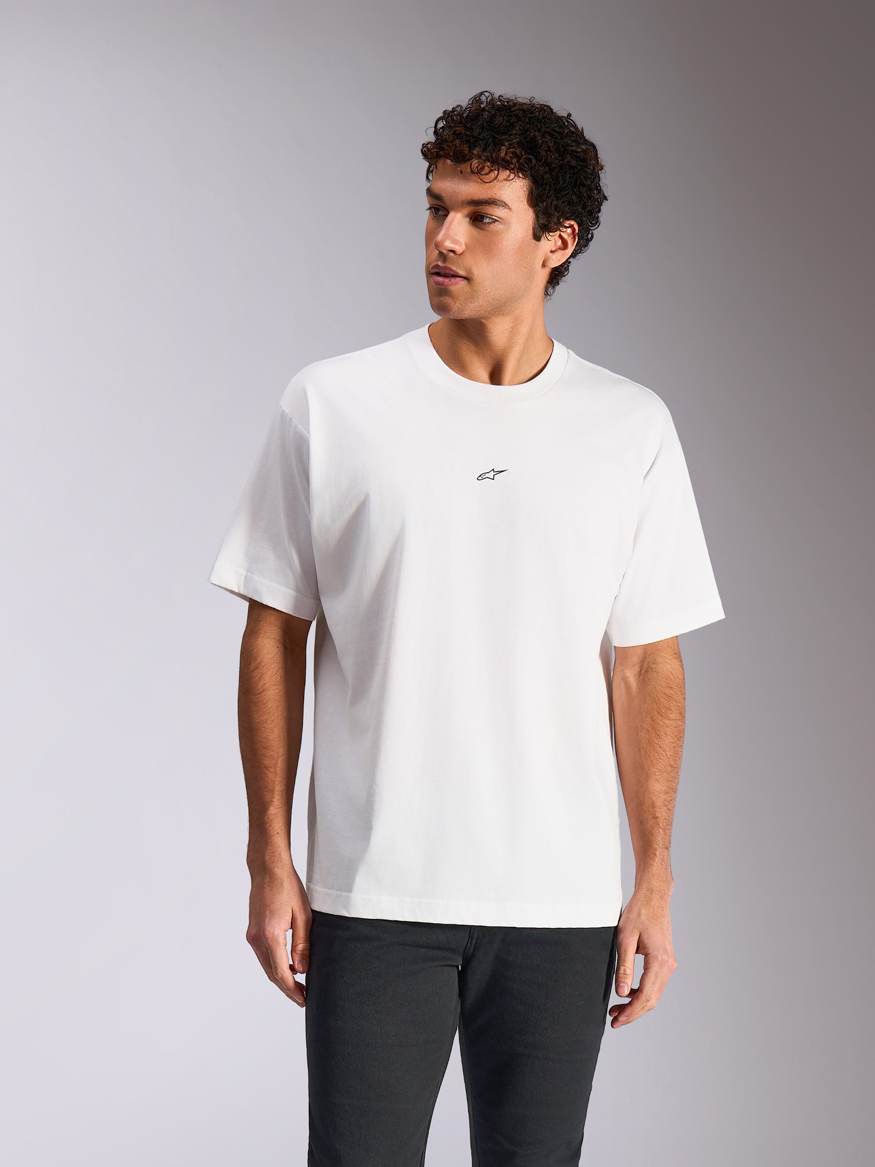 Alpinestars Focused Oversized CSF Tee, t-shirt a maniche corte, bianco, piccolo logo Astars nero sul petto, vestibilità rilassata indossata dal modello, streetwear casual motorsport