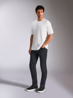 Alpinestars Focused Oversized CSF Tee, t-shirt a maniche corte, bianca, con piccolo logo Astars nero sul petto, indossata da un modello con pantaloni scuri e sneakers nere, streetwear casual ispirato al motorsport
