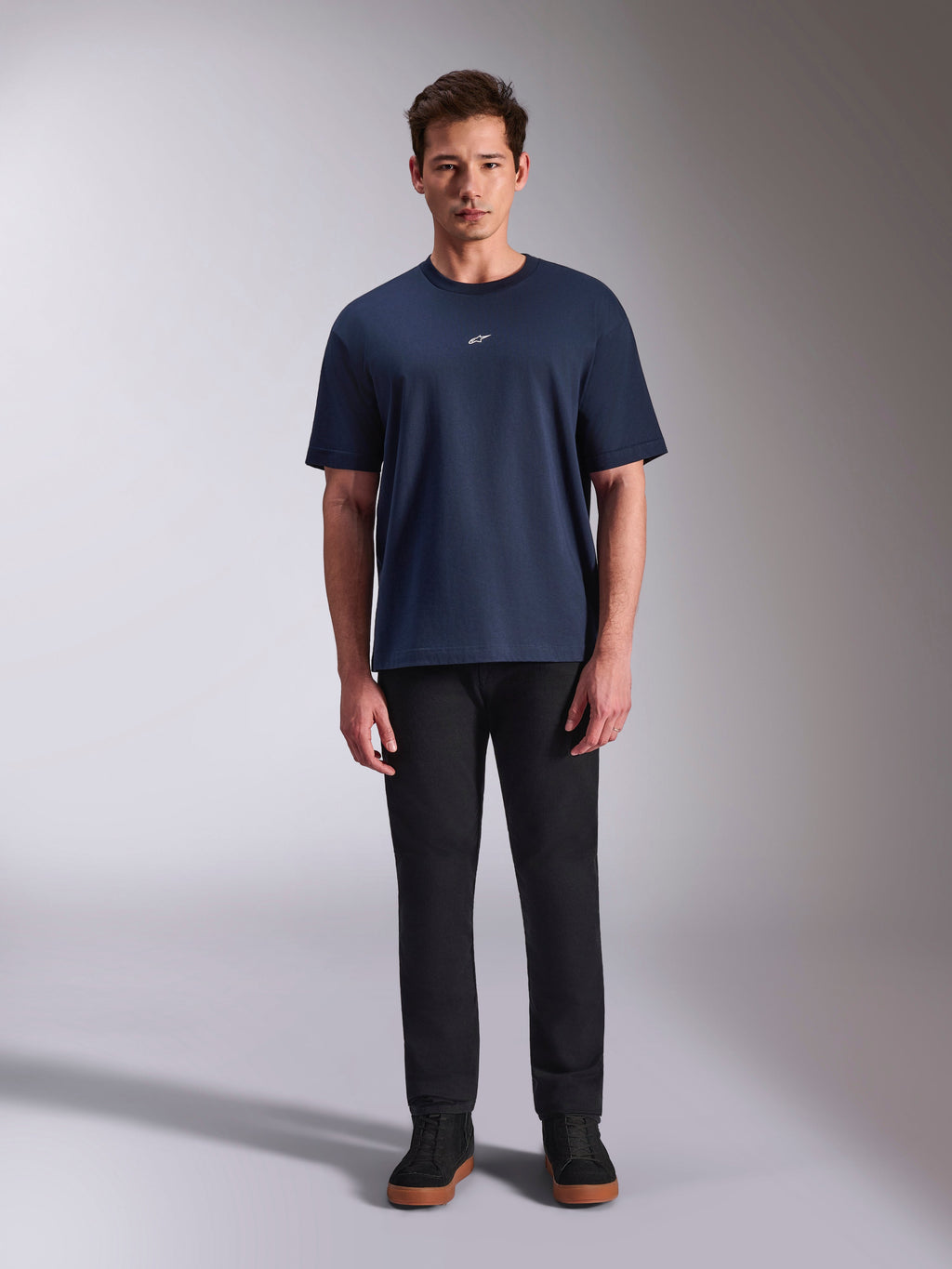 Alpinestars Focused Oversized CSF Tee, t-shirt a maniche corte, blu navy, piccolo logo Astars bianco sul petto, vestibilità oversize, abbinata a pantaloni neri e sneakers nere, streetwear casual ispirato al motorsport