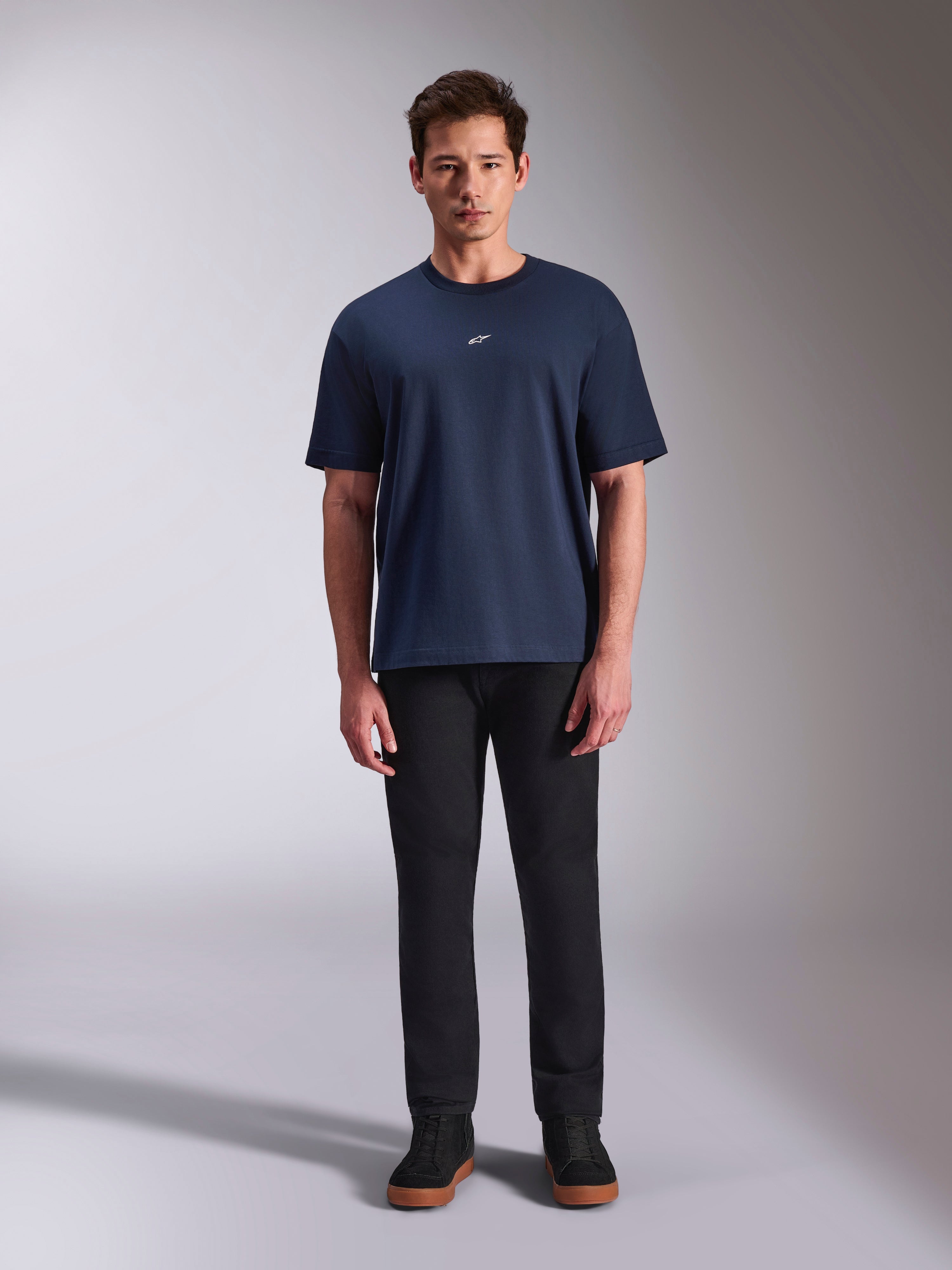 Alpinestars Focused Oversized CSF Tee, t-shirt a maniche corte, blu navy, piccolo logo Astars bianco sul petto, vestibilità oversize, abbinata a pantaloni neri e sneakers nere, streetwear casual ispirato al motorsport