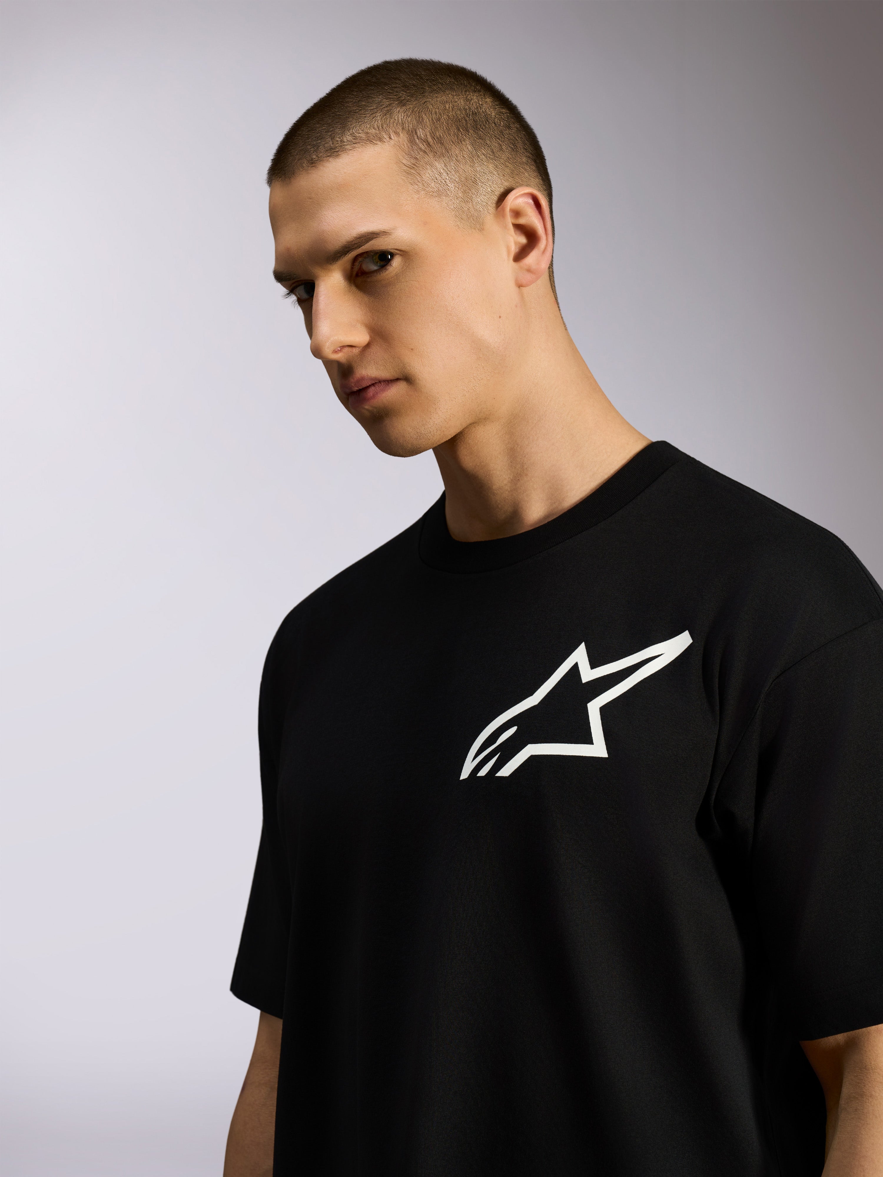 T-shirt Alpinestars One Oversized CSF, maglietta a maniche corte, nero, logo Astars bianco, indossata da un modello, abbigliamento casual lifestyle streetwear